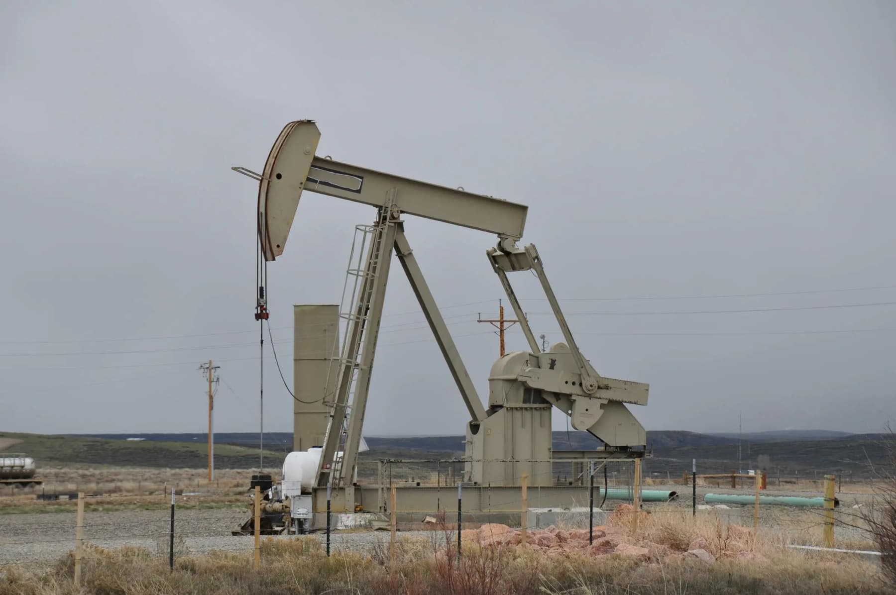 Pumpjack against a muted overcast sky in an open landscape